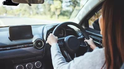 Driver holding steering wheel inside a car