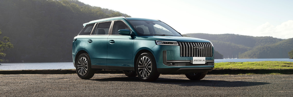 Teal Jaecoo SUV parked beside a lake